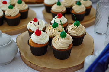 Cupcakes with cream, decorated with cherries