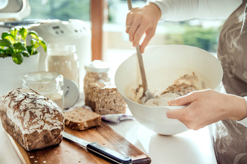 Kitchen utensils and woman preparing dough for homemade bread