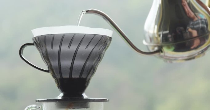 Making drip coffee over green background