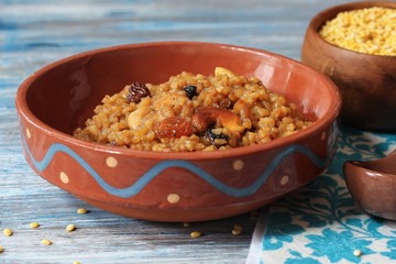 Homemade sweet pongal topped with raisins nuts, selective focus