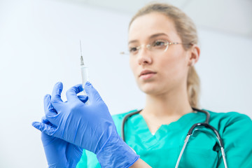 Female doctor prepares syringe to vaccinate. Horizontal view.