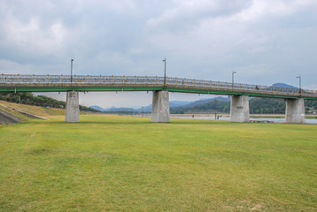 Fototapeta premium The Riverside Green Lawn and Concrete Bridge