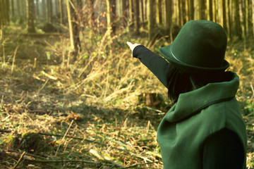 Elegant female ranger points into the distance of her forest