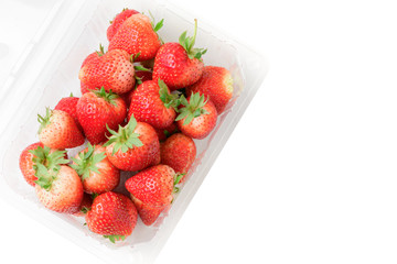fresh strawberries in plastic box isolated
