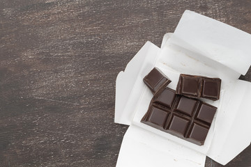 Open carton box with dark chocolate bar