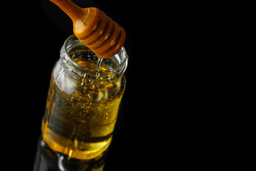 Fototapeta na wymiar Honey jar with dipper and flowing honey