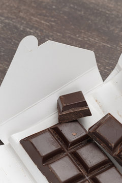 Open carton box with dark chocolate bar