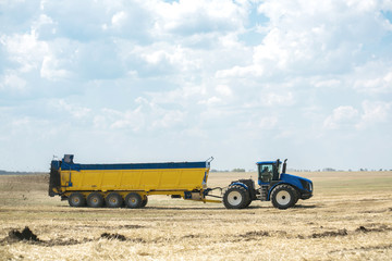 Obraz premium the tractor fertilizes the field with manure. A large trailer. Sowing. Agroindustry.Pole before sowing.