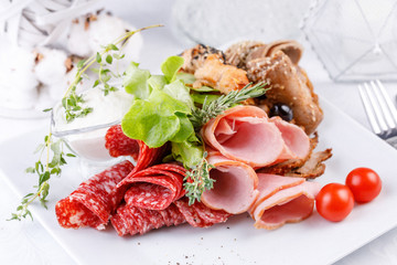 Exquisite meat plate, slicing different types of meat products.