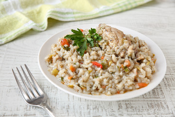 Delicious, homemade traditional bulgarian chicken stew with rice and vegetables in white plate on a rustic wooden table. Selective focus and shallow depth of field