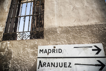 Ancient facade with sign destination madrid and aranjuez in the village of Chinchon, province Madrid, Spain.