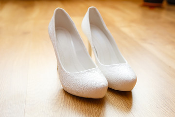 Bride's white shoes on floor