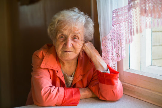 Portrait of an elderly woman sitting near the window.