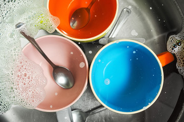 sink with cups and cutlery  for washing  in kitchen