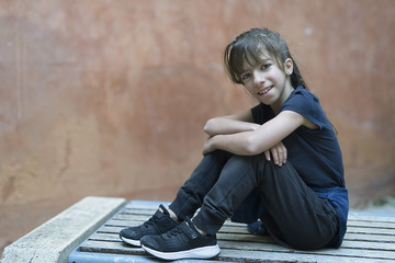 10 year old girl sitting on a wooden bench