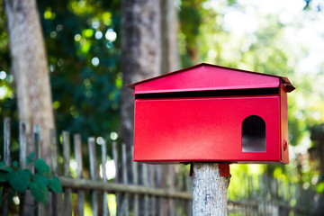 Red mailbox located in front of the house to receive mail.