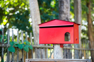 Red mailbox located in front of the house to receive mail.