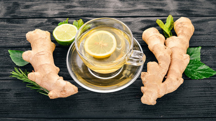 Tea with mint, ginger and lemon. Hot drink On a wooden background. Top view. Copy space.