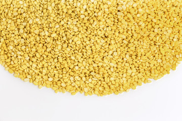 A lot of yellow split mung dal or moong dal pile isolated on white background with copy space for text. Concept food for healthy. Mung dahl dried food ingredient.