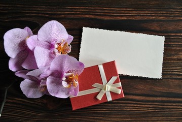 Prezent i orchidea na drewnianym tle