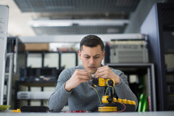 Young man working on robotic technology indoors