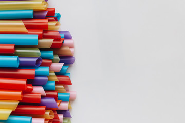 pile of colorful cocktail straws over white background