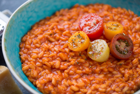 Close-up of tomato risotto topped with fresh sliced cherry tomatoes, selective focus
