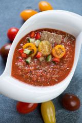 White bowl with tomato soup gazpacho, elevated view, vertical shot, close-up
