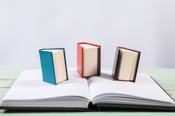 Pile of miniature books on wooden background. With copy space for your text