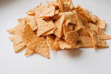 pile of delicious crispy nachos on white background, traditional Mexican cuisine