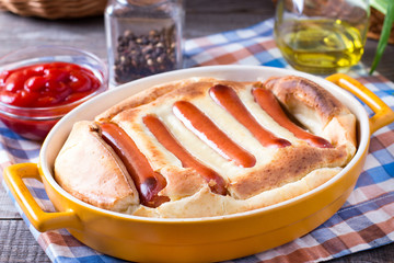 English food: toad in the hole into a baking dish close up on the table
