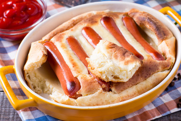 English food: toad in the hole into a baking dish on the table.