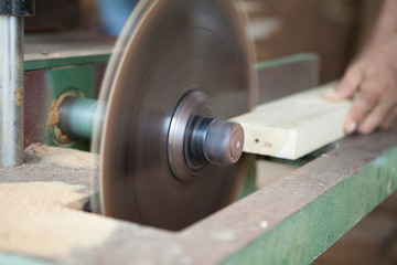 hands of the carpenter or craftsman cut a piece of wood to Machine Electronic Table Circular saw blade