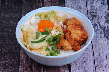 Jasmine rice with deep fried Chicken topped  soft boil eggs and fried pork with mixed vegetablein Japanese style.