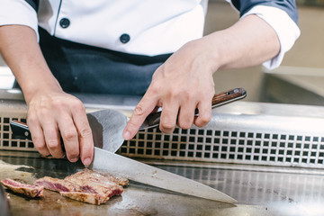 Hand of man take cooking of meat with vegetable grill, Chef cooking wagyu beef in Japanese teppanyaki restaurant
