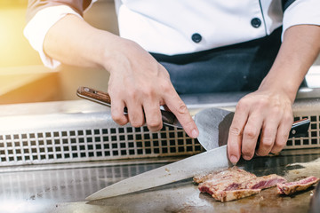 Hand of man take cooking of meat with vegetable grill, Chef cooking wagyu beef in Japanese teppanyaki restaurant