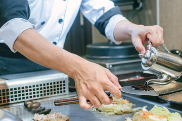 Hand of man take cooking of meat with vegetable grill, Chef cooking wagyu beef in Japanese teppanyaki restaurant