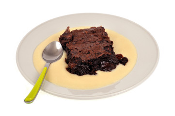 Assiette avec brownie et crème anglaise sur fond blanc 