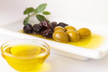 fresh,tasty, dark,green olives served in olive oil on white background