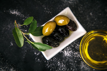 Fototapeta na wymiar fresh,tasty, dark,green olives served in olive oil on dark background