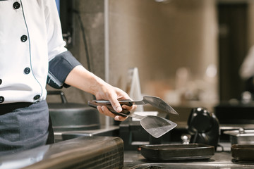 Hand of man take cooking of meat with vegetable grill, Chef cooking wagyu beef in Japanese teppanyaki restaurant