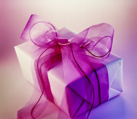 Geschenkpaket mit großer lila Schleife