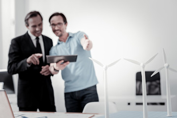 My model. Silhouettes of two men that keeping smile on faces and looking forward while having discussion