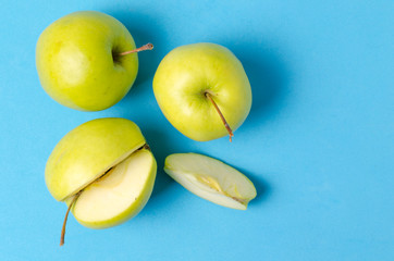 Green apples on a bright, clean, blue background.