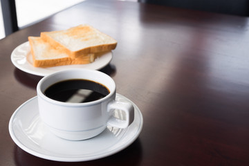 A cup of Coffee with bread on teble in the morning