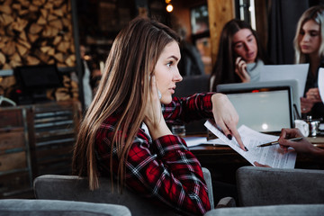 beautiful young businesswoman talking on the phone in a cafe and smiling