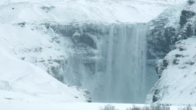 Skogafoss, the great and beautiful waterfall in Iceland during winter. Snow blizzard in Iceland near famous Skogafoss waterfall.
