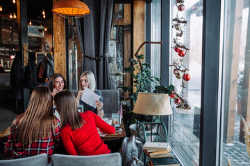 Obraz premium Group of happy business people analyzing business charts in a cafe.