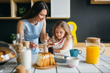 Mother and daughter making breakfast together at home 