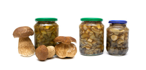 marinated mushrooms in the glass jars on white background